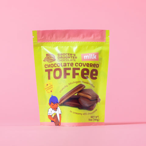 Packaging of Grocer's Daughter Milk Chocolate Covered Toffee on a pink background