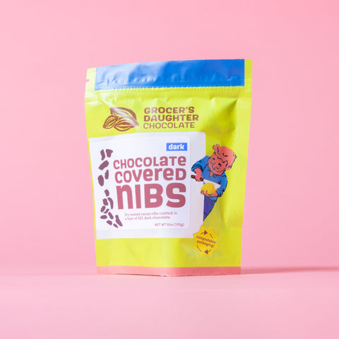 Grocer's Daughter Chocolate chocolate covered nibs package on a pink background