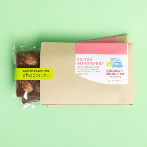 Packaged salted almond bar chocolate product on a green background, with branding and product information visible.