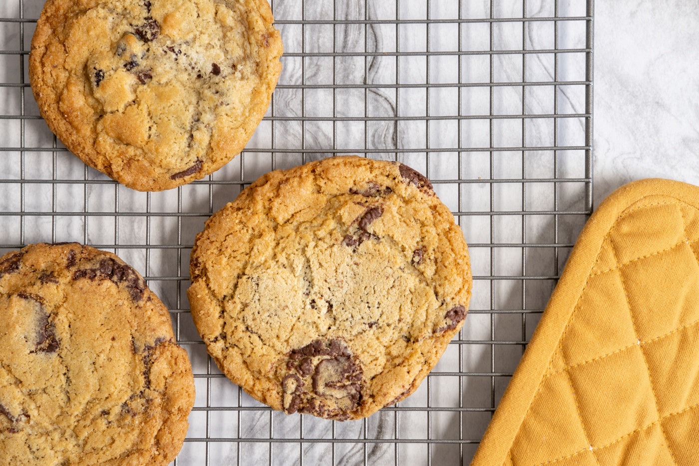GDC chocolate ship cookies on a cooling rack with a mustard yellow hot pad